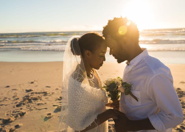 Couple sharing a tender moment on the beach at sunset